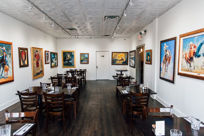 Interior, framed paintings, rows of tables and chairs